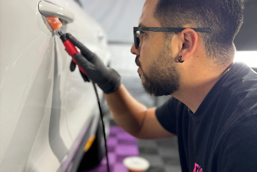 Tasha Car Detailing technician machine-polishing a car panel during paint correction in Miami